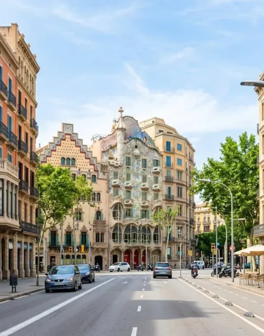 Vista amplia de una calle del barrio Eixample en Barcelona con arquitectura modernista característica, fachadas limpias y luminosas bajo luz mediterránea