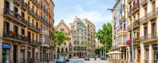 Vista amplia de una calle del barrio Eixample en Barcelona con arquitectura modernista característica, fachadas limpias y luminosas bajo luz mediterránea